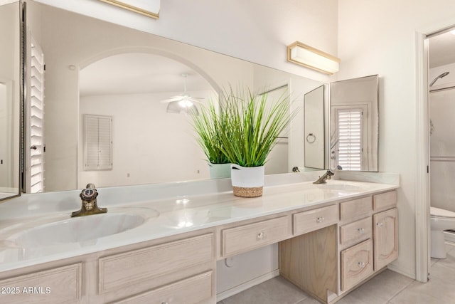 bathroom featuring double vanity, toilet, a ceiling fan, and a sink