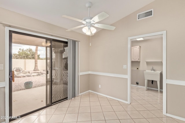 unfurnished room featuring light tile patterned floors, baseboards, visible vents, lofted ceiling, and ceiling fan