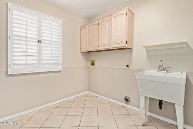 washroom with baseboards, light tile patterned flooring, cabinet space, electric dryer hookup, and washer hookup