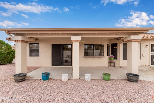 back of house with stucco siding, a patio, and ceiling fan