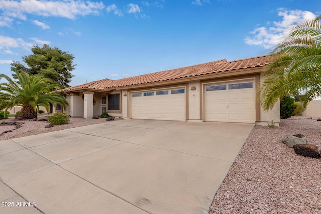 view of front of property featuring concrete driveway, a tiled roof, a garage, and stucco siding