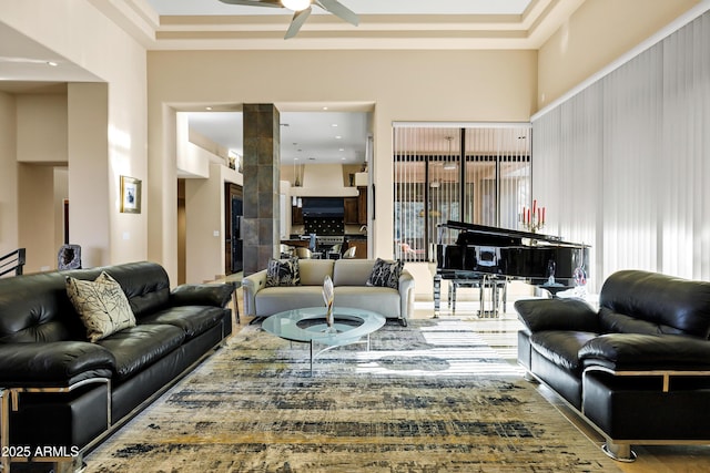 living room featuring ceiling fan and a high ceiling