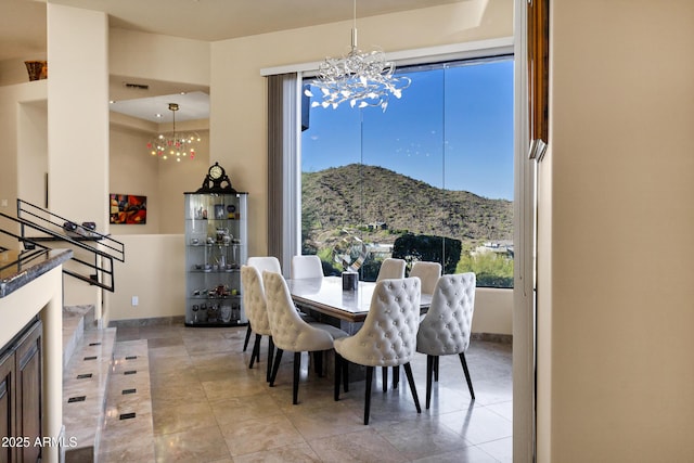 tiled dining room featuring a chandelier, visible vents, a mountain view, and baseboards