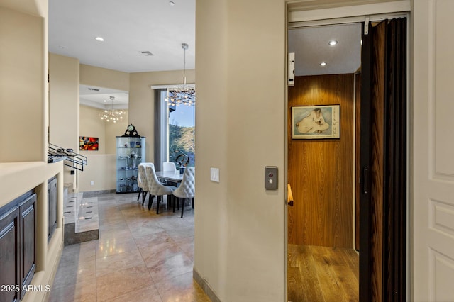 corridor featuring recessed lighting, baseboards, elevator, a chandelier, and light tile patterned flooring