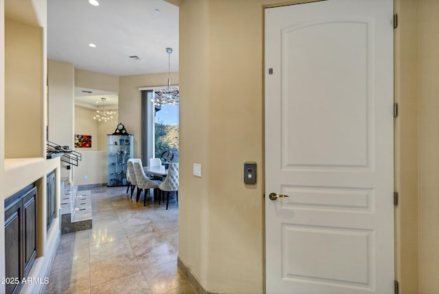 hall with an inviting chandelier, baseboards, and recessed lighting