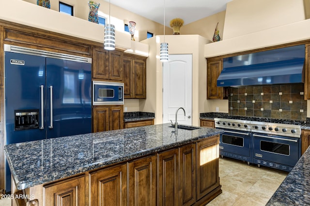 kitchen featuring extractor fan, a sink, high quality appliances, backsplash, and pendant lighting