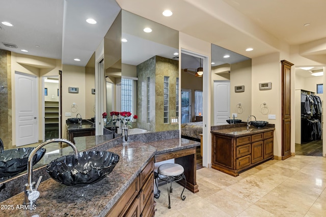 bathroom featuring recessed lighting, two vanities, a sink, visible vents, and a walk in closet