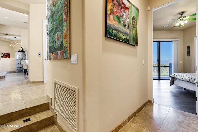 hallway featuring baseboards, visible vents, and tile patterned floors