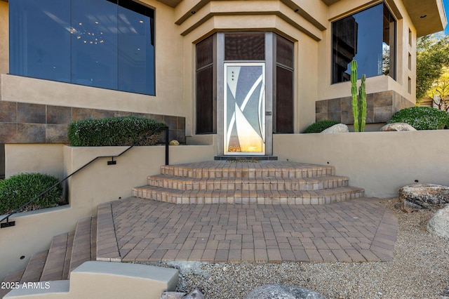 doorway to property featuring stucco siding