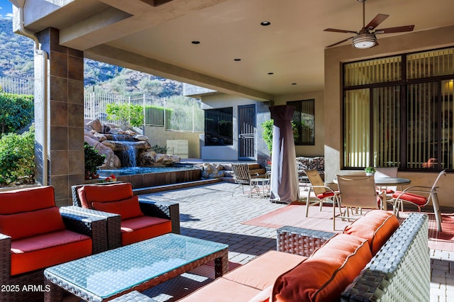 view of patio with fence, an outdoor living space, a ceiling fan, and outdoor dining space