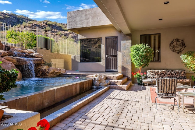 view of patio / terrace with fence and a mountain view