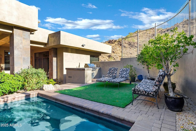 view of pool with a patio area, fence, and area for grilling