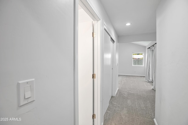 corridor featuring light carpet and vaulted ceiling