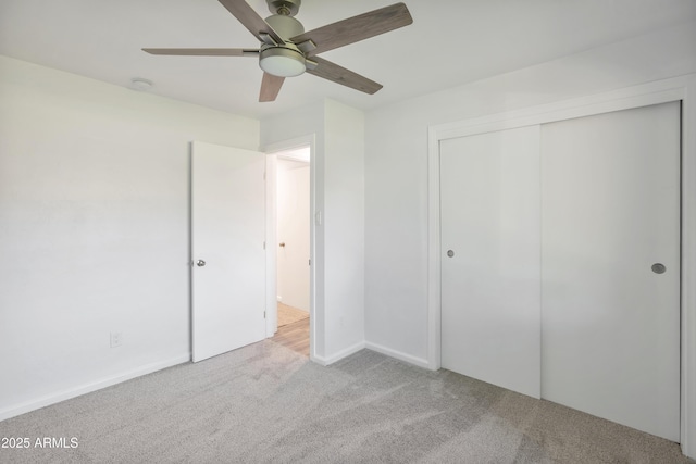 unfurnished bedroom featuring light colored carpet, ceiling fan, and a closet