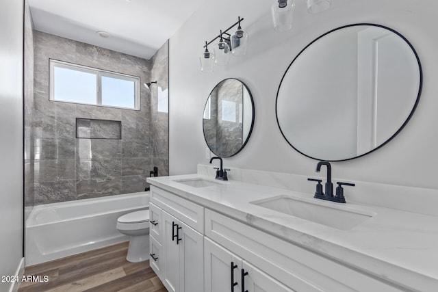 full bathroom featuring vanity, toilet, hardwood / wood-style flooring, and tiled shower / bath combo