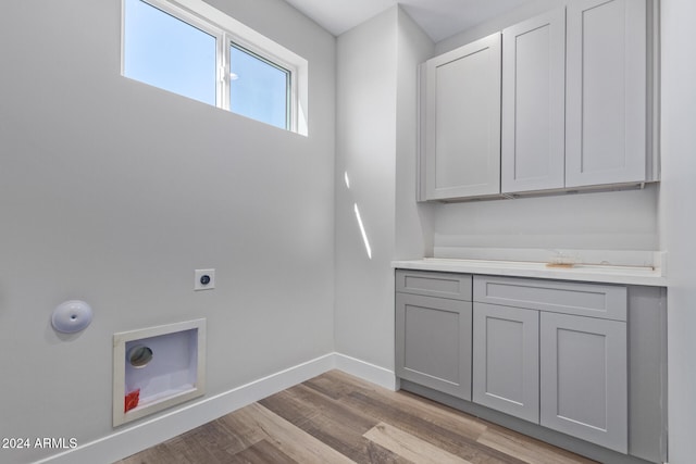 laundry room with light hardwood / wood-style flooring, electric dryer hookup, and cabinets