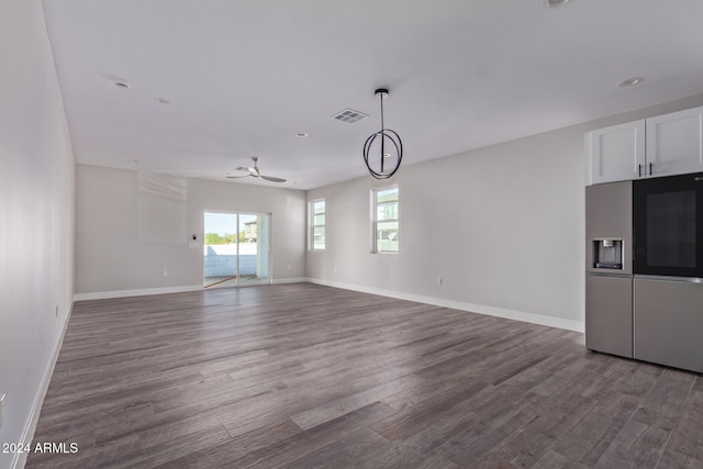 unfurnished living room featuring dark hardwood / wood-style floors and ceiling fan