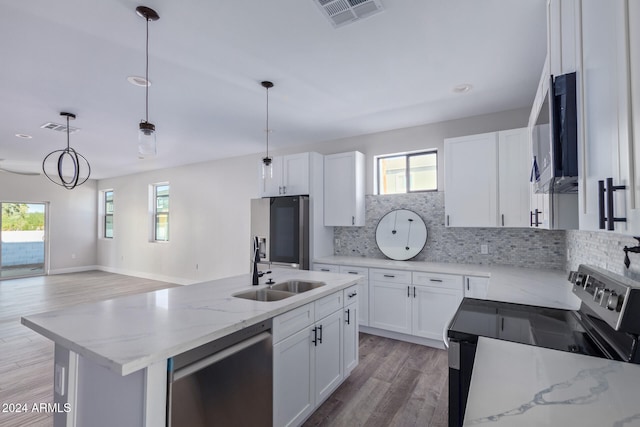 kitchen with a kitchen island with sink, hanging light fixtures, light wood-type flooring, white cabinetry, and appliances with stainless steel finishes