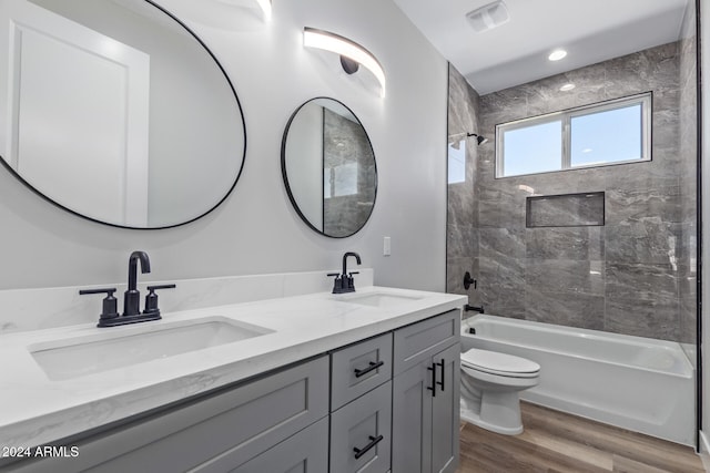 full bathroom featuring vanity, toilet, hardwood / wood-style flooring, and tiled shower / bath combo