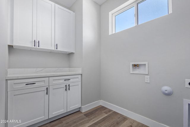 clothes washing area with cabinets, hardwood / wood-style floors, washer hookup, and electric dryer hookup