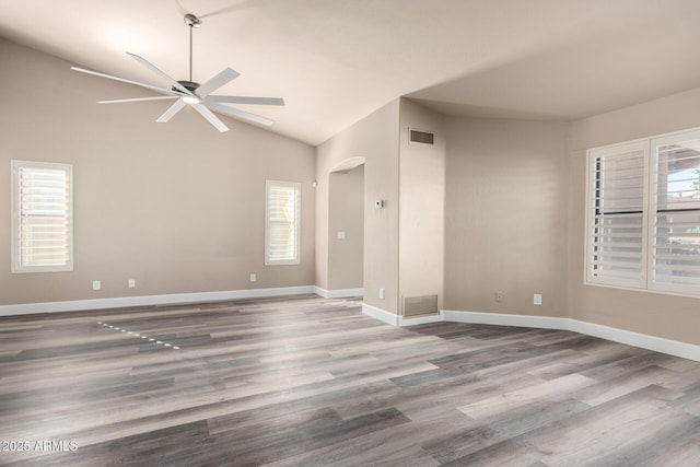 empty room with plenty of natural light, visible vents, and wood finished floors