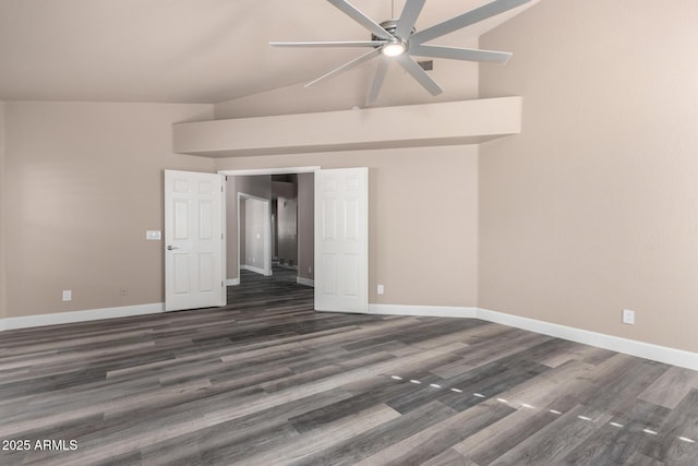 spare room with dark wood-style flooring, vaulted ceiling, and baseboards