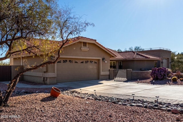 view of front of property featuring driveway, fence, an attached garage, and stucco siding