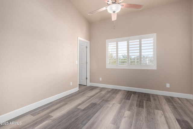 spare room featuring ceiling fan, baseboards, and wood finished floors