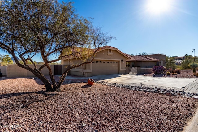 ranch-style house featuring a garage, fence, concrete driveway, and stucco siding