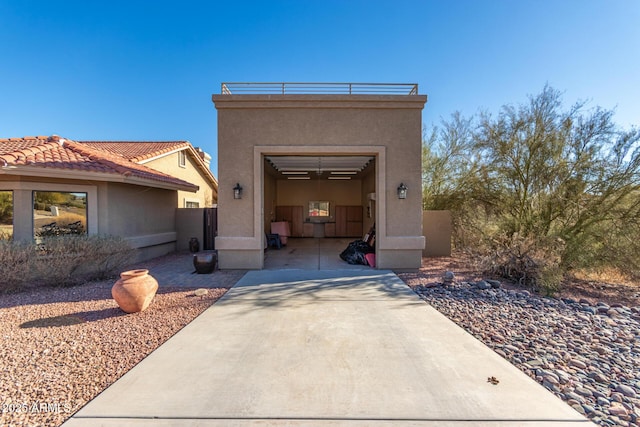 view of front of house with a garage, driveway, a tiled roof, and stucco siding