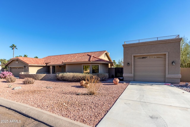 view of front of house with driveway, a tile roof, a garage, and stucco siding