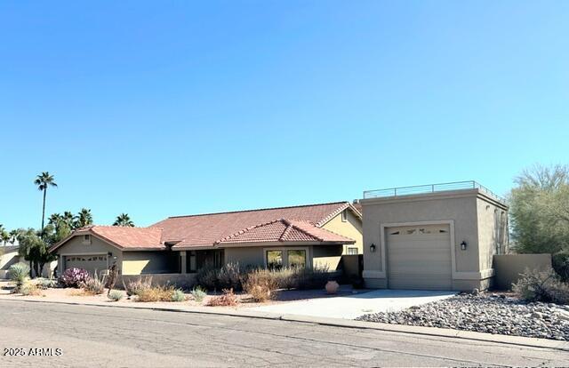 view of front of property featuring concrete driveway, an attached garage, and stucco siding