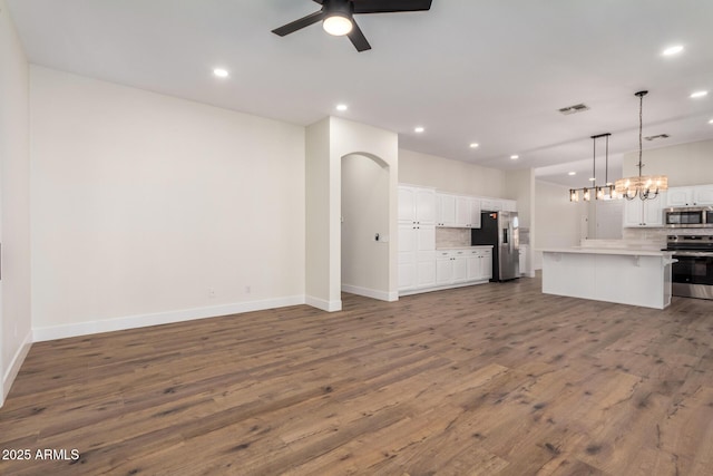 kitchen with white cabinets, appliances with stainless steel finishes, decorative backsplash, and decorative light fixtures