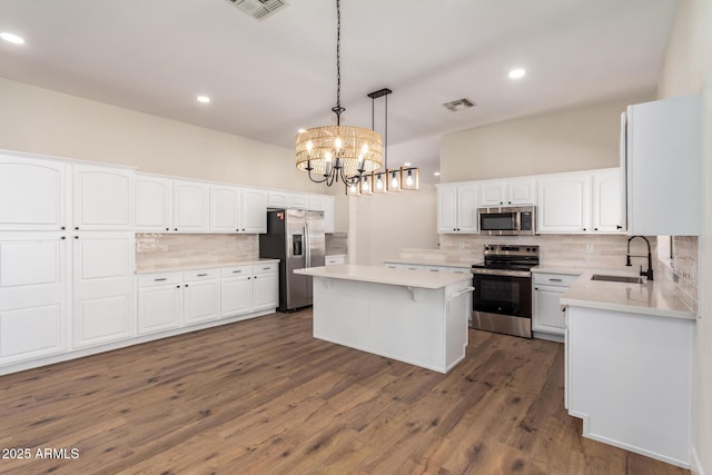 kitchen featuring a kitchen island, sink, white cabinetry, and stainless steel appliances