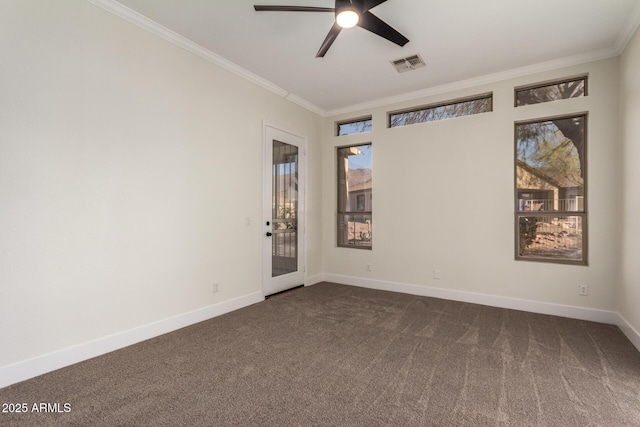 spare room featuring dark colored carpet, ceiling fan, and crown molding