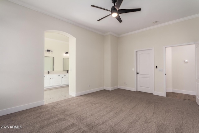 unfurnished bedroom featuring carpet flooring, ceiling fan, ornamental molding, and connected bathroom