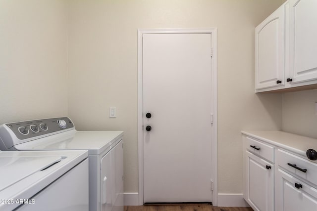 clothes washing area with dark hardwood / wood-style flooring, cabinets, and washing machine and clothes dryer