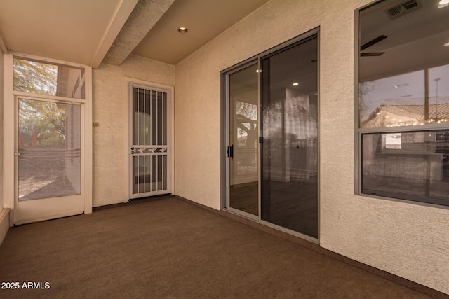 unfurnished sunroom featuring ceiling fan