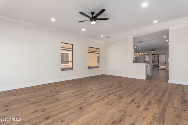 unfurnished living room featuring wood-type flooring, ceiling fan with notable chandelier, and crown molding