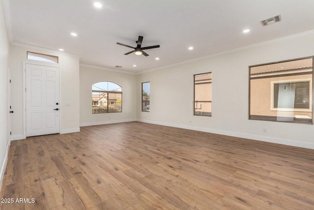 unfurnished living room featuring crown molding, ceiling fan, and light wood-type flooring