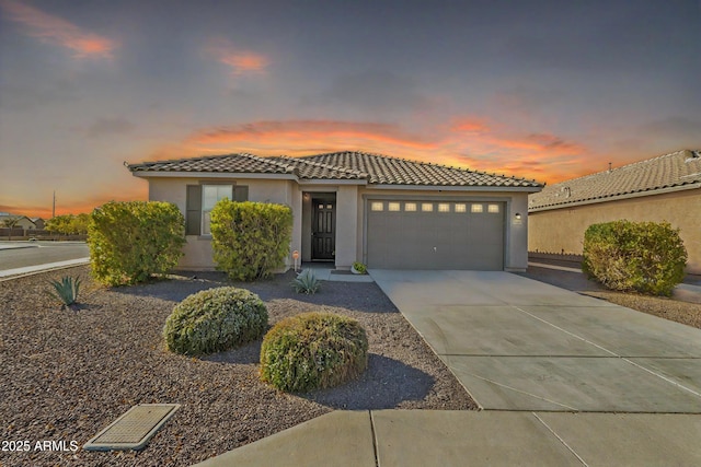 7580 W Darrel Rd, Laveen, AZ 85339 - mediterranean / spanish house featuring a tiled roof, stucco siding, an attached garage, and concrete driveway