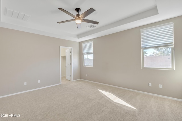 7580 W Darrel Rd, Laveen, AZ 85339 - empty room featuring light colored carpet, ceiling fan, healthy amount of natural light, and a raised ceiling
