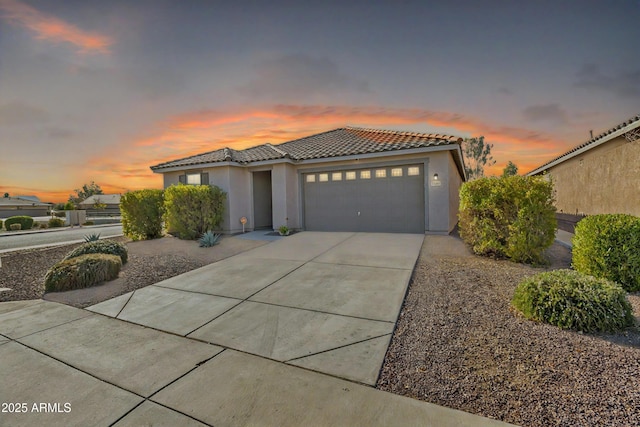 7580 W Darrel Rd, Laveen, AZ 85339 - view of front of home with a tiled roof, a garage, stucco siding, and driveway