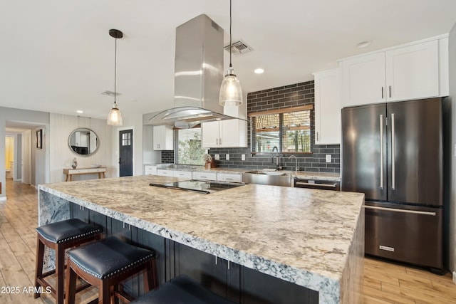 8730 E Montecito Ave, Scottsdale, AZ 85251 - kitchen with a sink, freestanding refrigerator, white cabinetry, island range hood, and cooktop