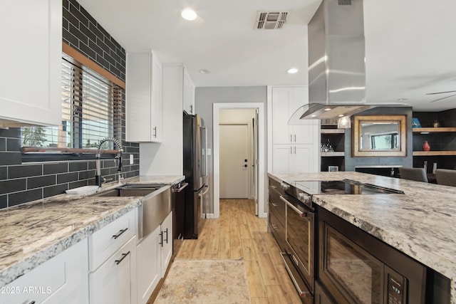 8730 E Montecito Ave, Scottsdale, AZ 85251 - kitchen featuring white cabinets, stainless steel appliances, island exhaust hood, and visible vents
