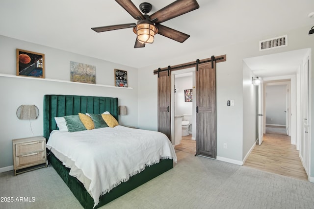 8730 E Montecito Ave, Scottsdale, AZ 85251 - carpeted bedroom featuring ceiling fan, visible vents, a barn door, baseboards, and connected bathroom
