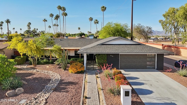 8730 E Montecito Ave, Scottsdale, AZ 85251 - ranch-style home with a garage, a mountain view, a shingled roof, and driveway