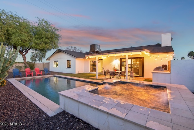 8730 E Montecito Ave, Scottsdale, AZ 85251 - back of house featuring a chimney, central AC, a fenced in pool, a patio, and stucco siding