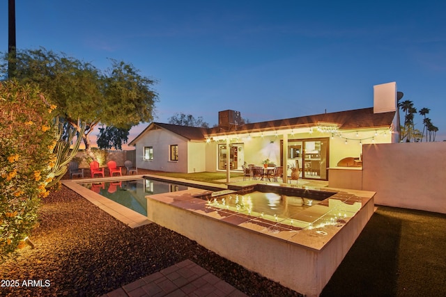 8730 E Montecito Ave, Scottsdale, AZ 85251 - back of property featuring french doors, a chimney, a fenced in pool, a patio, and stucco siding