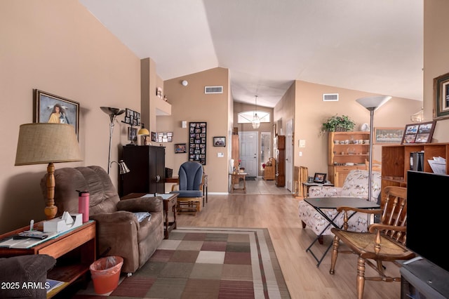 living room with hardwood / wood-style floors and high vaulted ceiling